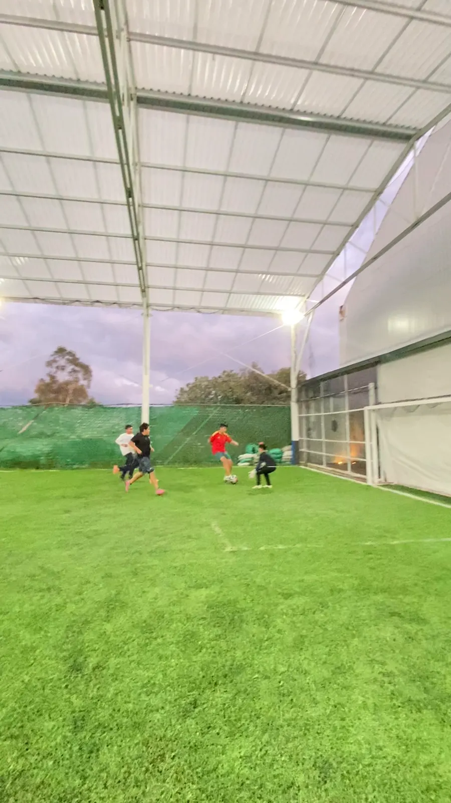 Partido de niños en la cancha de fútbol techada