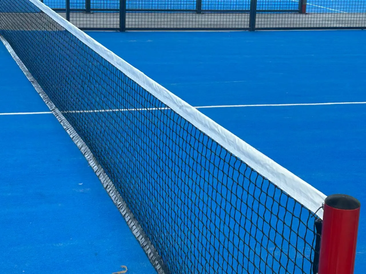 Red de pádel sobre el piso azul de la cancha